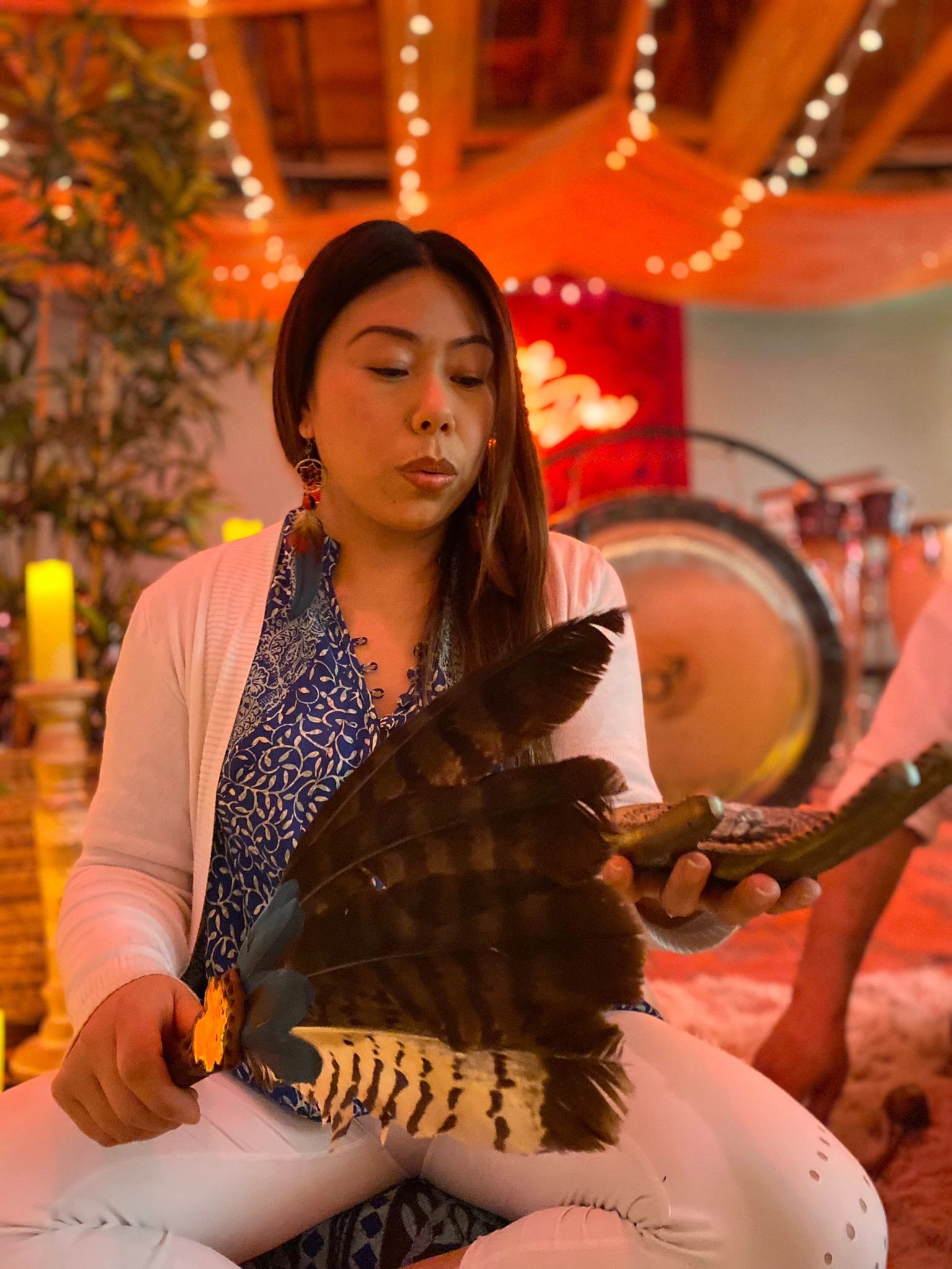 Practitioner in a warm, ceremonial atmosphere with ambient lighting