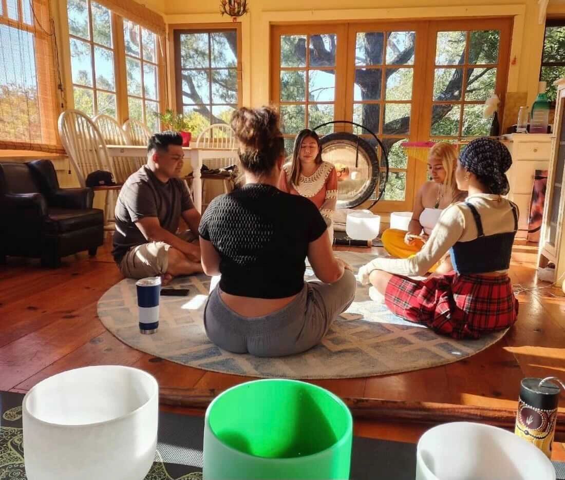 Six people gathered in a circle for a cacao sitting